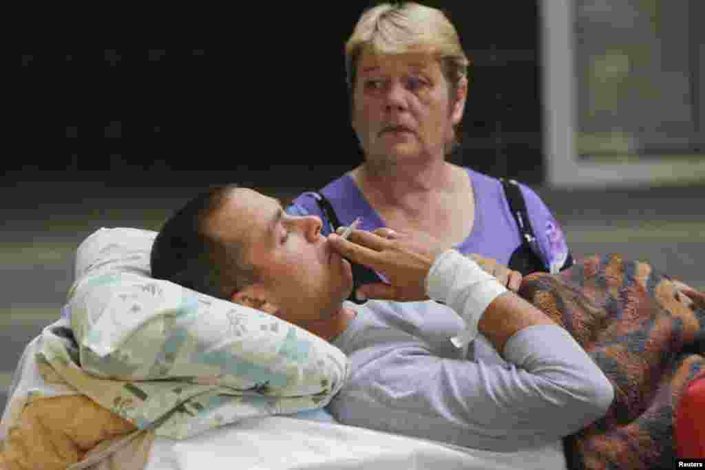 An injured Ukrainian serviceman talks to a relative before being put into ambulance in Kyiv, Sept. 2, 2014.