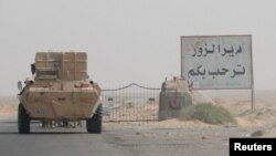 FILE - A road sign welcomes people to the town of Deir el-Zour in Syria, Sept. 20, 2017.