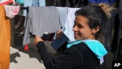 Edimar Valera, a migrant from Venezuela, stands among drying clothes in the Casa del Migrante shelter in Reynosa, Mexico, on Dec. 15, 2022.
