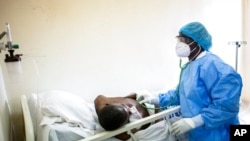 Un médecin utilise un stéthoscope pour écouter la respiration d'un patient atteint de COVID-19 au CHU de Fann à Dakar, au Sénégal, le 13 mai 2020.