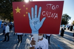 FILE - A protester from the Uighur community living in Turkey holds an anti-China placard during a protest in Istanbul, Oct. 1, 2020, against what they allege is Chinese oppression of Muslim Uighurs in far-western Xinjiang province.