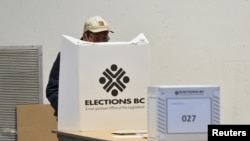 FILE - A voter casts a ballot in Vancouver, British Columbia, Canada, October 24, 2020. 