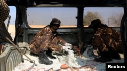 FILE - Afghan security personnel inspect a car filled with explosives which was seized from a Taliban insurgent in Jalalabad, Afghanistan Dec. 10, 2019.