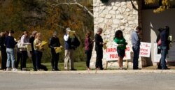FILE - In this Feb. 28, 2020 photo, voters wait in line at an early polling site in San Antonio.