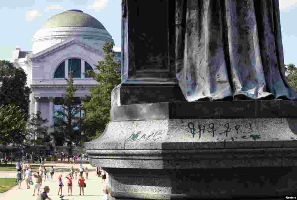A close up shows markings in green paint on the base of a statue of Joseph Henry, the first secretary of the Smithsonian Institution, outside the institution's Washington headquarters, July 29, 2013. 