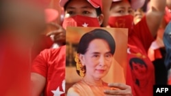 A Myanmar migrant holds up an image of Aung San Suu Kyi during a demonstration outside the Myanmar embassy in Bangkok on February 1, 2021, after Myanmar's military detained the country's de facto leader Suu Kyi and the country's president in a coup.