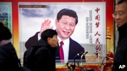 រូបឯកសារ៖ បុរសម្នាក់ដើរកាត់បដារូបប្រធានាធិបតីចិនលោកស៊ី ជីនពីង នៅ​ក្រុងប៉េកាំង ប្រទេស​ចិន។ 