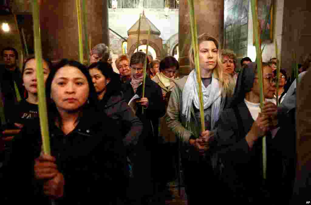 Christian pilgrims hold palm fronds during the Palm Sunday procession in the Church of the Holy Sepulcher, traditionally believed by many to be the site of the crucifixion, in Jerusalem's Old City.