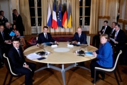 French President Emmanuel Macron, center left, Russian President Vladimir Putin, center right, German Chancellor Angela Merkel and Ukrainian President Volodymyr Zelenskiy, left, attend a working session at the Elysee Palace in Paris, Dec. 9, 2019.
