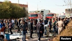 FILE - Kurdish security forces inspect the site of a car bomb attack in Irbil, the capital of Iraq's Kurdistan region, Nov. 19, 2014.