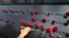 Norma Molina, de San Antonio, Texas, coloca flores en los nombres de bomberos en el Memorial del 11 de septiembre en la ciudad de Nueva York el 9 de septiembre, de 2019.