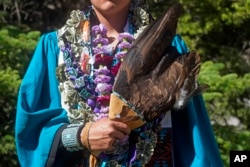 Dayne Hudson, member of the Paiute Indian Tribe of Utah, holds his eagle feather fan before the Canyon View High School graduation Wednesday, May 25, 2022, in Cedar City, Utah. (AP Photo/Rick Bowmer)