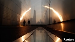 A man walks through the 9/11 Empty Sky memorial at sunrise across from New York's Lower Manhattan and One World Trade Center in Liberty State Park in Jersey City, New Jersey, September 11, 2013. 