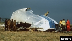 FILE - In this Dec. 23, 1988 photo, Scottish rescue workers and crash investigators search the area around the cockpit of Pan Am flight 103 in a farmer's field east of Lockerbie Scotland after a mid-air bombing killed all 259 passengers and crew,