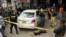 FILE - Investigators examine a damaged car at the site of a shooting incident, in Karachi, Pakistan, July 28, 2021. Gunmen riding on a motorcycle fired into the car that was carrying two Chinese workers.