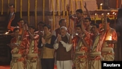 Japan's Prime Minister Shinzo Abe (front, 3rd L) and his Indian counterpart Narendra Modi perform a religious ritual during evening prayers on the banks of the river Ganges in Varanasi, India, December 12, 2015.