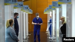 FILE - Doctors wait at their vaccination booths for people at the Health Service Executive mass vaccination center for people over 85 at The Helix theatre, amid the outbreak of the coronavirus disease, in Dublin, Ireland, Feb. 20, 2021.