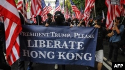 Para pengunjuk rasa memegang spanduk dan mengibarkan bendera AS sambil berpawai dari Chater Garden ke konsulat AS di Hong Kong, 8 September 2019. Mereka mencari dukungan internasional untuk mendukung tuntutannya. (Foto: AFP)