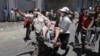 Des manifestants antigouvernementaux transportent un homme blessé lors d'affrontements avec les forces yéménites à Taiz, au Yémen, le 5 avril 2011. (AP Photo / Yemen Lens, File)
