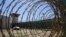 FILE - In this April 17, 2019, photo, reviewed by U.S. military officials, the control tower is seen through the razor wire inside the Camp VI detention facility in Guantanamo Bay Naval Base, Cuba. 