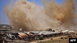 FILE - Smoke rises above opposition-held areas of the Daraa province countryside during airstrikes by Syrian regime forces, June 27, 2018.