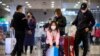 Travelers wear face masks as they stand in the arrivals area at Beijing Capital International Airport in Beijing, Jan. 23, 2020.