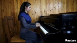Negin Ekhpulwak, leader of the Zohra orchestra, an ensemble of 35 women, practises on a piano at Afghanistan's National Institute of Music, in Kabul, Afghanistan, April 9, 2016. 