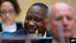 FILE - Kenya's President Uhuru Kenyatta, sitting with his defense team, smiles during an October hearing before the International Criminal Court in The Hague, Netherlands.