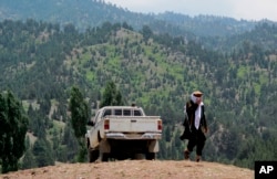 FILE - A Taliban militant walks in Shawal in Pakistani tribal region of North Waziristan, Aug. 12, 2013.