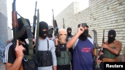 Earlier this year Islamic State militants seized a dam in Fallujah, flooding farmland on the outskirts of Baghdad and draining offshoots of the Euphrates River. Masked Sunni gunmen pose during a patrol outside Fallujah, Iraq, April 28, 2014.