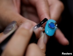 ภาพของ นาโอมิ อาริโมโตะ ช่างทำเล็บชาวญี่ปุ่น ขณะใช้ขยะพลาสติกมาดัดแปลงเป็นส่วนประกอบการทำเล็บ 3 มิติ ที่จังหวัดคานากาวา เมื่อ 21 ต.ค. 2567