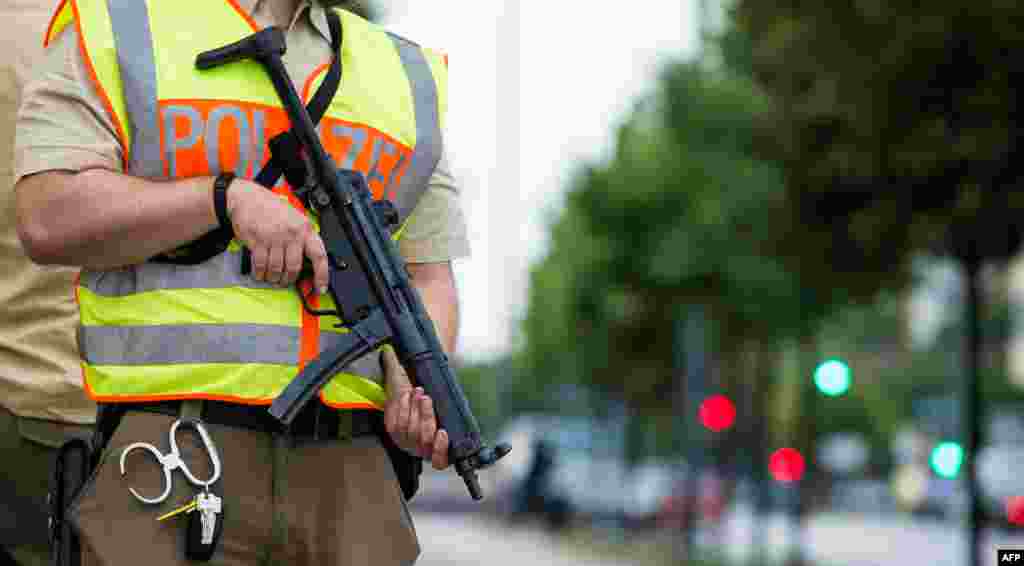 A policeman secures an area around the shopping mall (the Olympia Einkaufzentrum (OEZ) ) in Munich on July 22, 2016 following a shooting earlier.