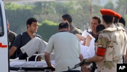 Egyptian medics and police escort former Egyptian President Hosni Mubarak into an ambulance after after he was flown by a helicopter to the Maadi Military Hospital from Torah prison, Cairo, August 22, 2013.