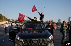 Turkish people wave the national flags on a car in Istanbul, Turkey, Saturday, July 16, 2016.