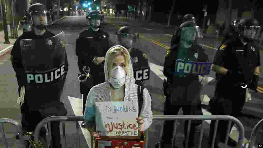 A relative, right, of one of the victims of explosion, wipes the face of a Turkish police officer, serving as a honor guard, during the funeral procession for two of the victims at Fatih mosque in Istanbul.