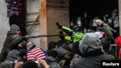 FILE - Protesters clash with police at the west entrance of the Capitol during a "Stop the Steal" protest at the U.S. Capitol in Washington, Jan. 6, 2021.