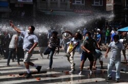 Nepalese protesters defying a government coronavirus lockdown to take part in a religious festival clash with riot police, in Lalitpur, Nepal, Sept. 3, 2020.