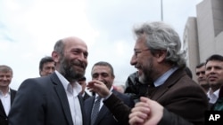 FILE - Journalists Can Dundar, right, and Erdem Gul, Ankara bureau chief of Cumhuriyet newspaper, speak before the start of their trial, hours before the attack on Can Dundar outside city's main courthouse in Istanbul, May 6, 2016. 