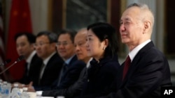FILE - Chinese Vice Premier Liu He, right, sits next to a translator and members of the Chinese delegation as senior U.S. and Chinese officials resume trade negotiations, Feb. 21, 2019, in the Indian Treaty Room of the Eisenhower Executive Office...
