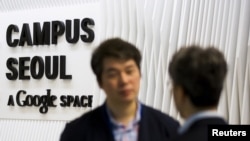 People talk at the entrance to the Google Campus start-up space in the Gangnam district of Seoul, May 8, 2015. 