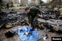 A Russian soldier checks a burned medical tent after rebels launched a mortar shell at a field hospital in west Aleppo, Syria, Dec. 5, 2016. Syrian rebels have said they would not accept Russian or Iranian monitors on the ground.