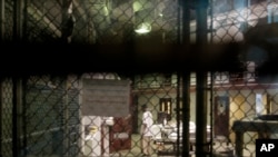 FILE - A prisoner walks through a communal pod inside an area of the Guantanamo Bay detention center known as Camp 6, at Guantanamo Bay Naval Base, Cuba, June 7, 2014.