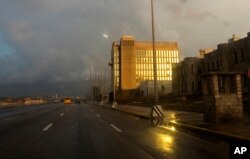 FILE - Rays from the setting sun shine on the facade of the United States Embassy, in Havana, Cuba, Oct. 14, 2017.