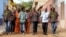 The eight members of Super Mama Djombo, including founder Ze Manel Fortes and composer Atchutchi, walk through the streets of Bissau's old town, Guinea-Bissau, May 2, 2012. (K. Thomas/VOA)