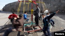 FILE - Turkish children are seen playing on a make-shift carousel.