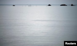 FILE - A fishing boat motors back to shore on the east coast of Natuna Besar.