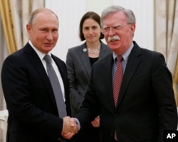 Russian President Vladimir Putin, left, and U.S. national security adviser John Bolton shake hands during their meeting in the Kremlin in Moscow, Oct. 23, 2018.