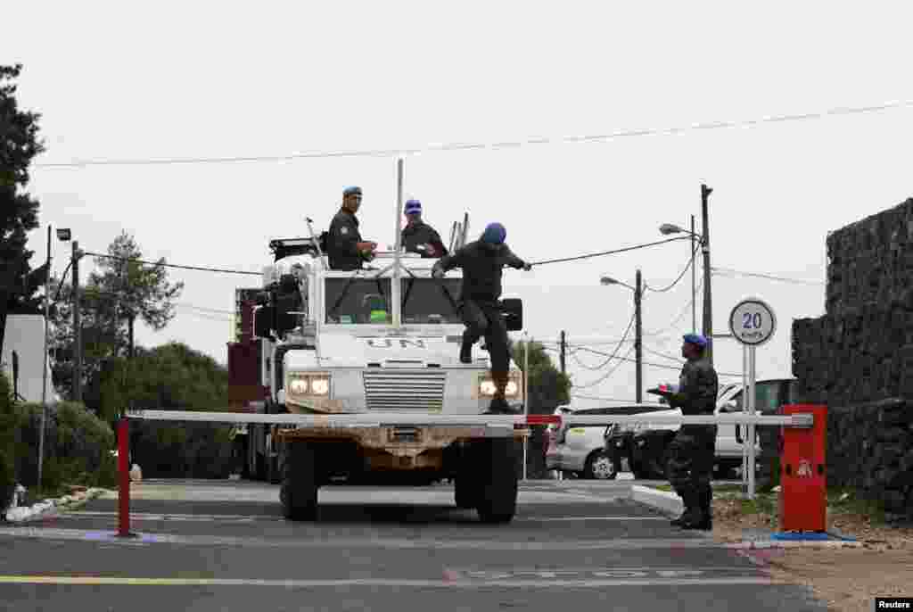 A United Nations armored car drives through a gate at a U.N. base near the Kuneitra border crossing between Israel and Syria, in the Golan Heights, March 8, 2013.