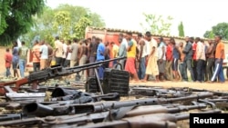 FILE - Suspected fighters and recovered weapons are shown in Bujumbura, Burundi, Dec. 12, 2015. Burundian President Pierre Nkurunziza's senior adviser says such images of unrest are propaganda intended to tarnish Burundi.