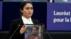 FILE - Jewher Ilham, daughter of Uyghur scholar Ilham Tohti holds a photo of her father during the Sakharov Prize ceremony at the European Parliament, in Strasbourg, France, Dec. 18, 2019. This week marks 10 years since Chinese authorities sentenced Ilham Tohti to life in prison.